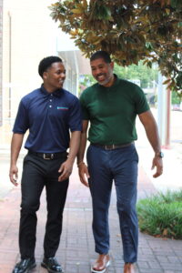 Adam Tolliver and George Stewart walk together outdoors, talking and laughing as they leave the Foundation’s office building.