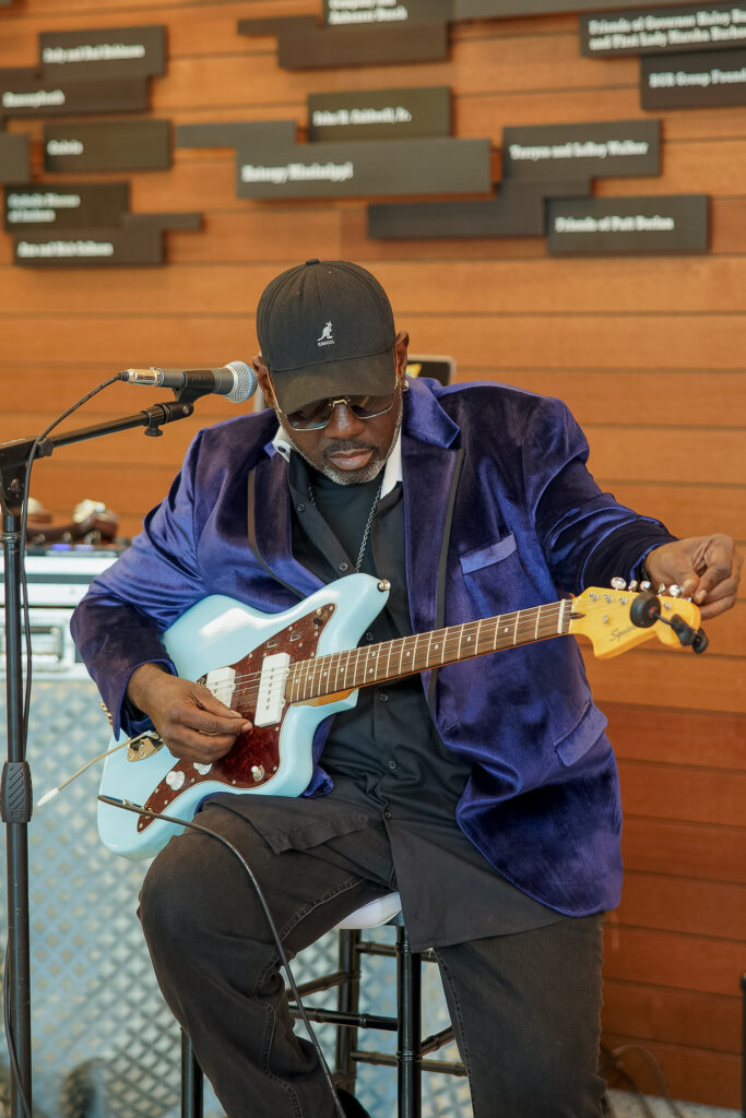 Blues musician Stevie J tuning his guitar during cocktail hour at the 35th Anniversary Celebration.