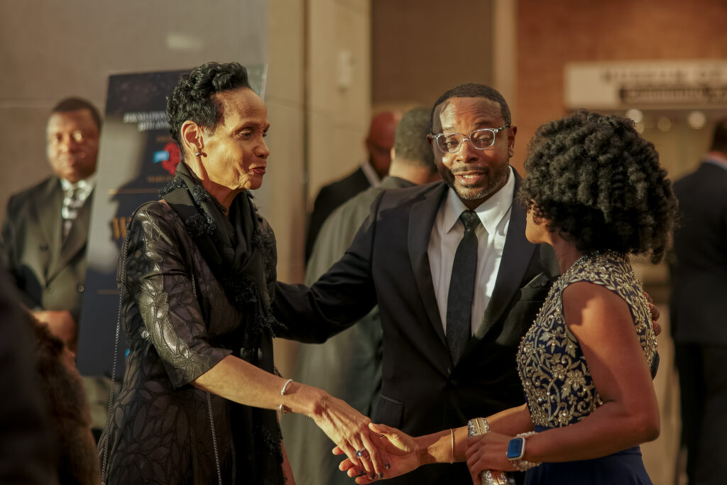 Cassio Batteast and Ebonee Johnikin greeting a guest at the anniversary event.