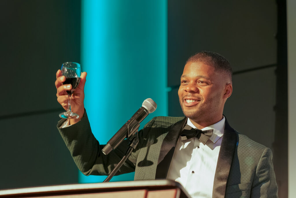 President and CEO Greg Johnson smiles while raising a glass from the podium during the Foundation for the Mid South’s 35th Anniversary celebration.