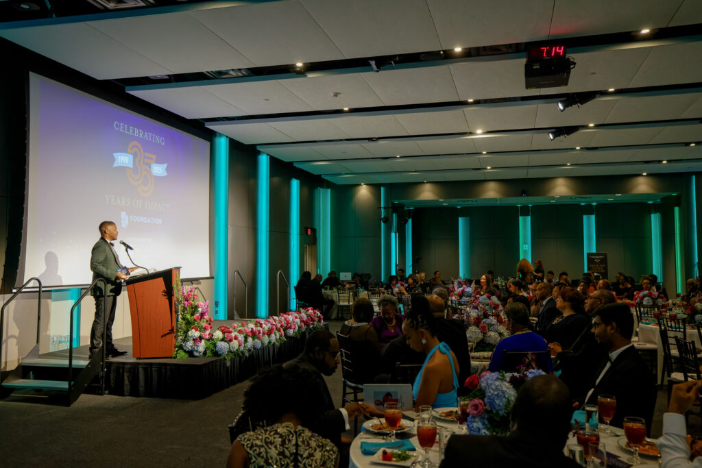 Wide shot of the 35th Anniversary auditorium with Greg Johnson speaking at the podium.