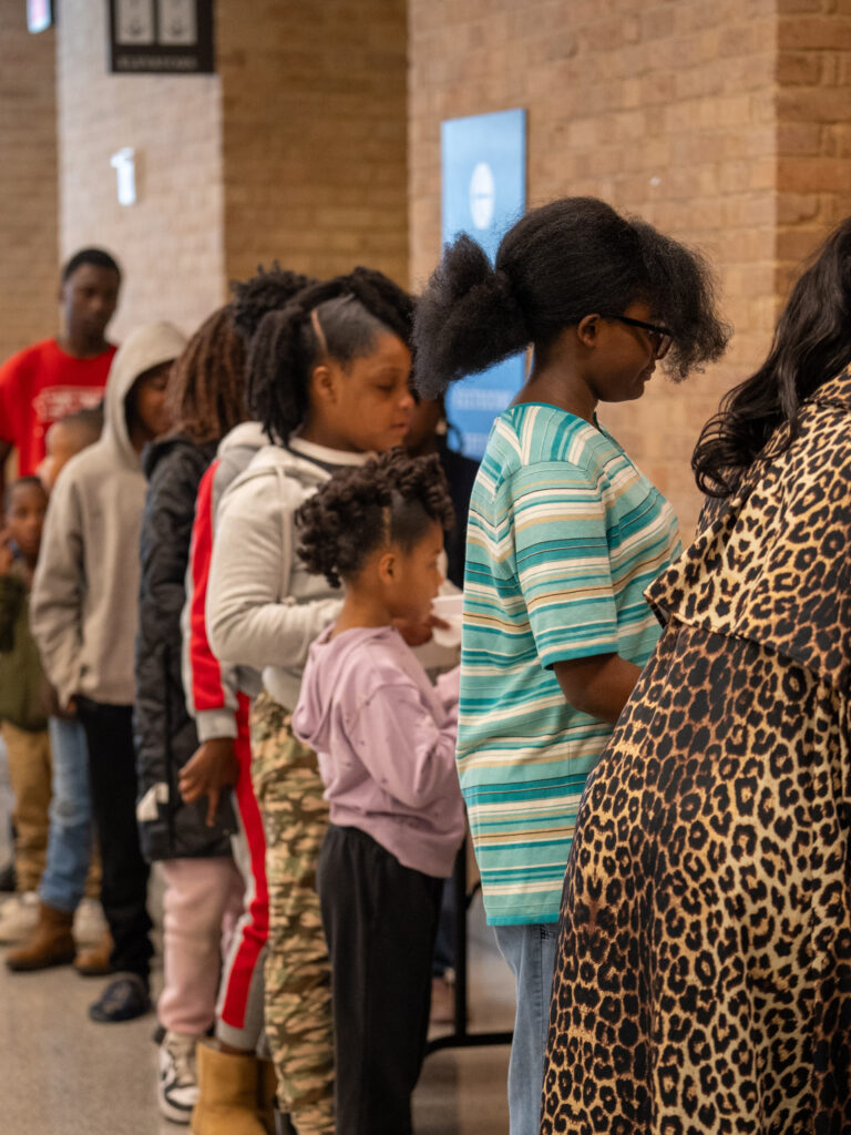 Children and families stand together inside the Two Mississippi Museums during MLK Day of Service.