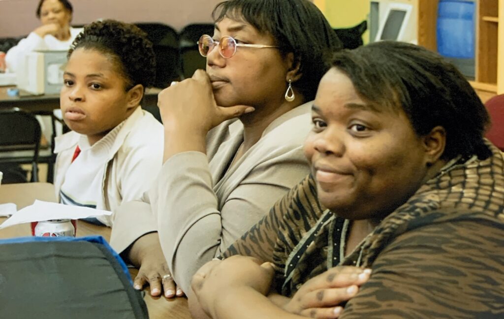 Community members seated at a table during a meeting or discussion session.